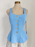 Blusa baby blue sin mangas con botones dorados y peplum